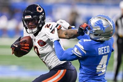 Sep 14, 2025; Detroit, Michigan, USA; Chicago Bears wide receiver DJ Moore (2) carries the ball defended by Detroit Lions cornerback D.J. Reed (4) during the first quarter of the game at Ford Field.